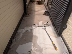 ベランダの古い防水膜を削り落とすケレン下地処理作業