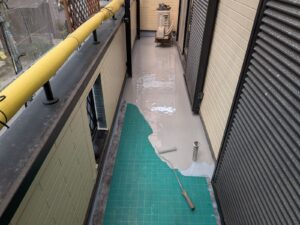 通気緩衝シートを敷いたベランダ床にウレタン防水材を1回目塗布する工程